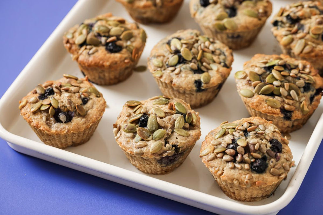 PACKD Vegan Banana and Blueberry Muffins in a white tray on a purple tabletop
