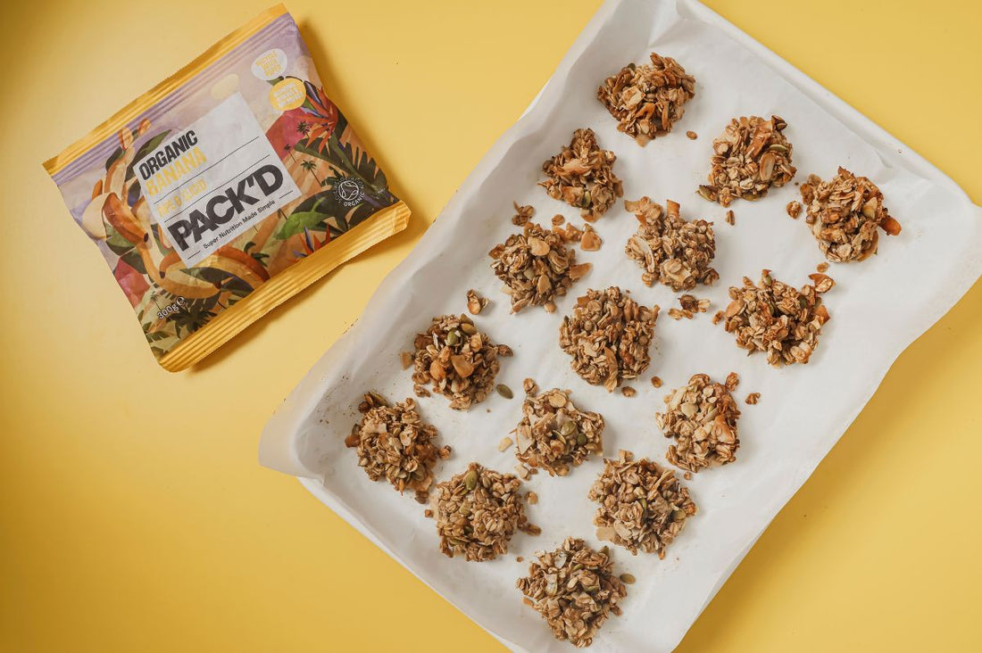 A tray of 15 granola clusters, next to a packet of PACKD frozen organic bananas