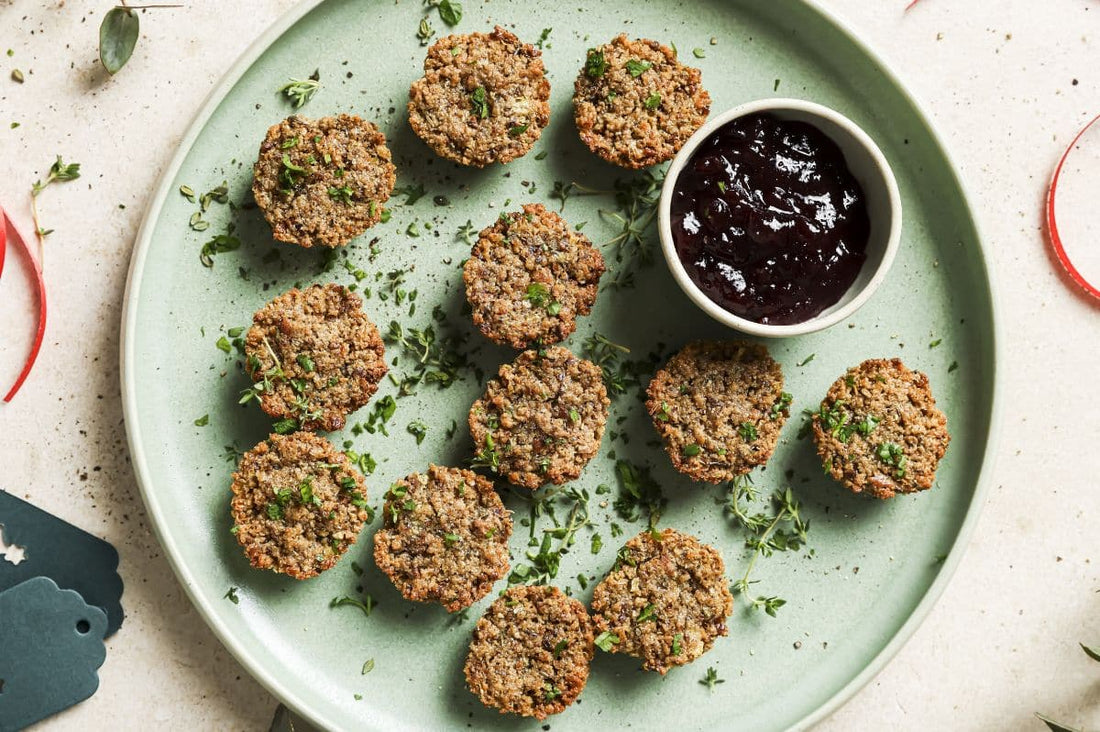 PACKD mini sage and onion stuffing bites on a green plate with a small pot of cranberry sauce