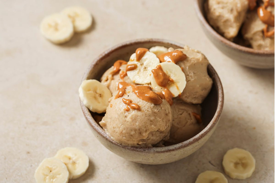 PACK'D's 3 ingredient Creamy Vegan Ice Cream in a bowl with banana slices on the table