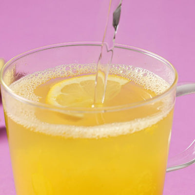 Glass cup with a PACKD Immunity Wellness Hottie drink being poured