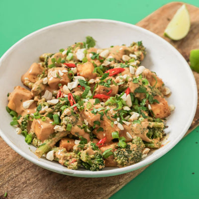 PACKD Vegan Peanut Butter Tofu Bowl in a bowl that is sat on a chipping board