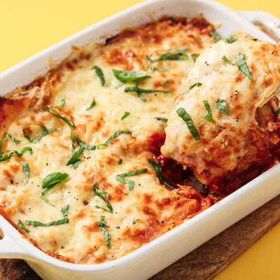 PACKD Vegan Spinach & Ricotta Cannelloni being spooned out of a white bowl