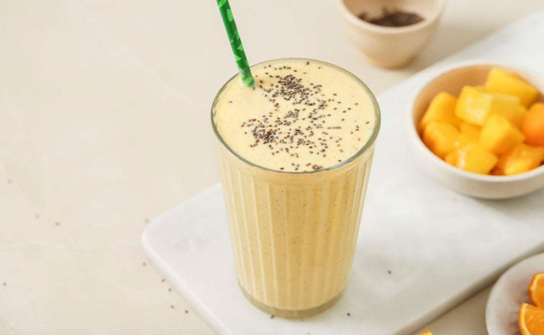 Creamy high protein mango and orange smoothie topped with chia seeds, made with PACK'D Organic Mango, served with fresh mango chunks and orange