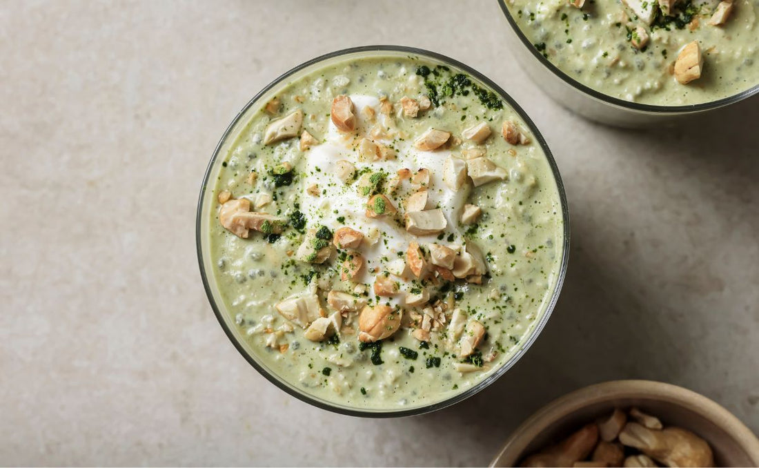 A close-up of a green Matcha and Cashew oat bowl topped with chopped toasted cashews and a dollop of yoghurt, featuring PACK'D frozen bananas.