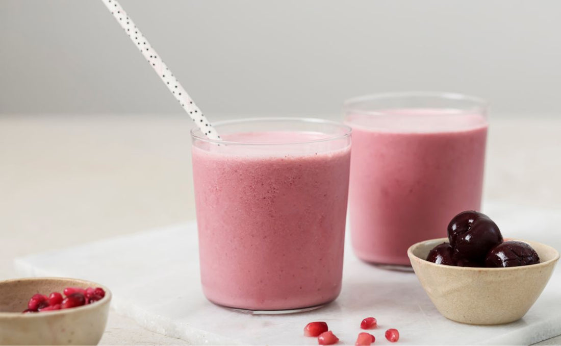 Bright pink skin glow smoothie in a glass, blended with PACK'D Organic Cherries, PACK'D Organic Pomegranate and Greek yoghurt